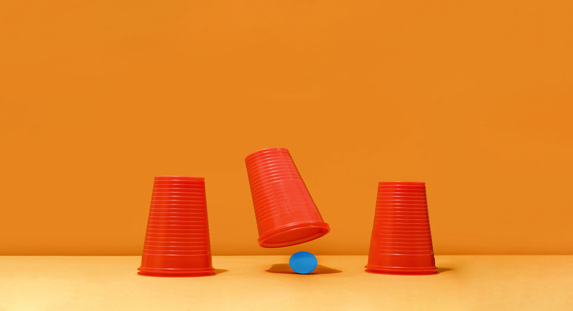 red cup lifted to show blue ball in three card monte type game