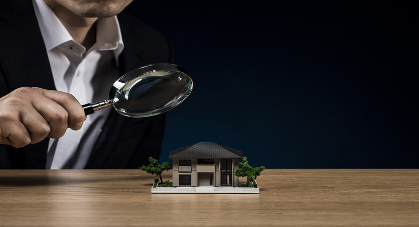 Person with magnifying glass suggesting that they're doing property inspections