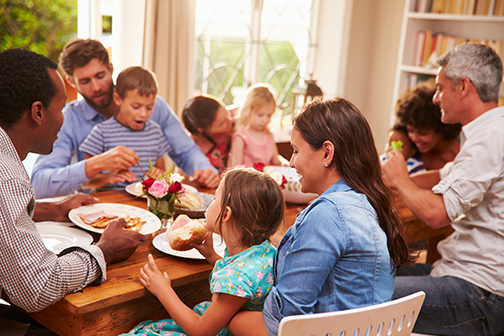 Family and friends sitting at a dining table during a fall resident event